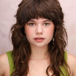 Headshot of Anna Faye Lieberman. A young, white woman with long, dark-brown hair and bangs. She is wearing a green tank top.