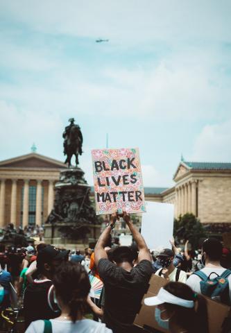 A protestor holds up a sign at a BLM protest in Philadelphia. Photo: Chris Henry via Unsplash