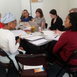 Cast members for <em>The Swallowing Dark</em> along with director Claire Moyer sit at their first table read rehearsal. 