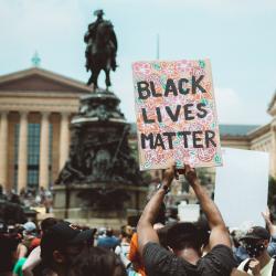 A protestor holds up a sign at a BLM protest in Philadelphia. Photo: Chris Henry via Unsplash