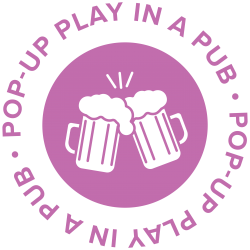Pop Up Play in a Pub logo. Purple text surrounds a pair of clinking beer mugs inside a purple circle