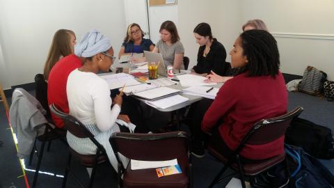 Cast members for <em>The Swallowing Dark</em> along with director Claire Moyer sit at their first table read rehearsal. 